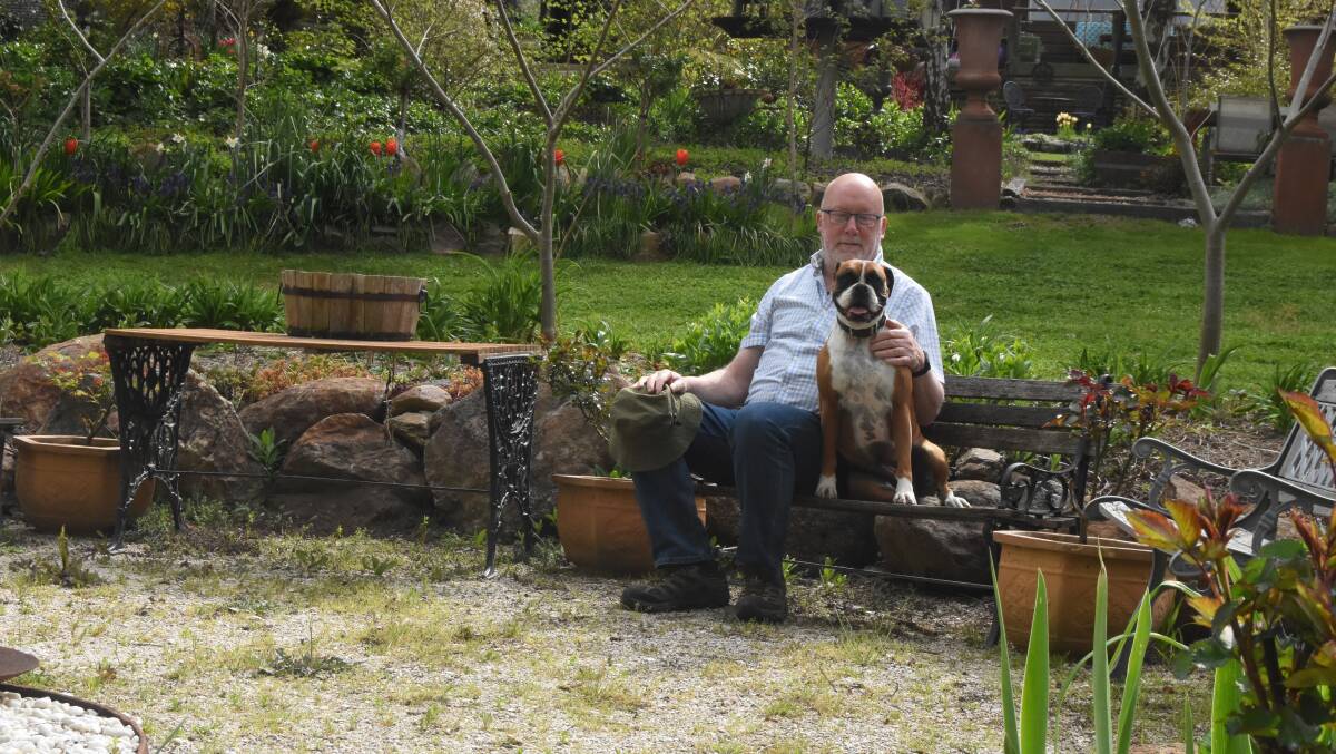 Robert Brown with Grace in the fire pit area of the garden ahead of the 2022 festival. Picture by Mark Logan.